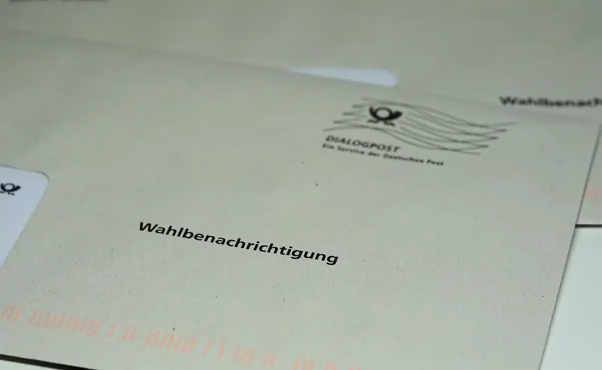 Voters in a polling place, some marking ballots in voting booths, others checking in at the registration table, fluorescent overhead lighting, daytime interior
