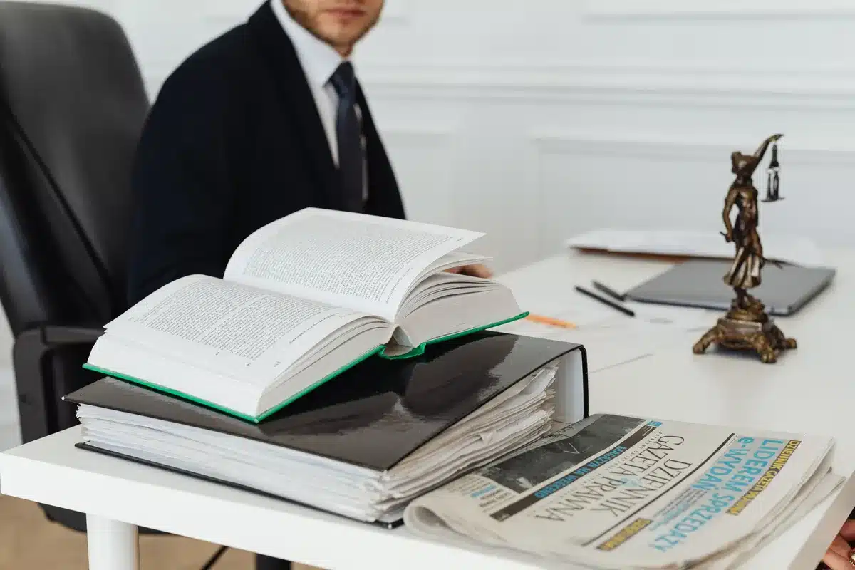 A gavel resting on a wooden desk with blurred law books in the background