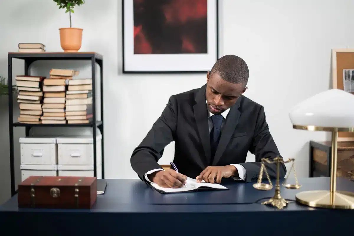 A leather-bound law book on a wooden desk, pages slightly open, a fountain pen beside it in dim study lighting