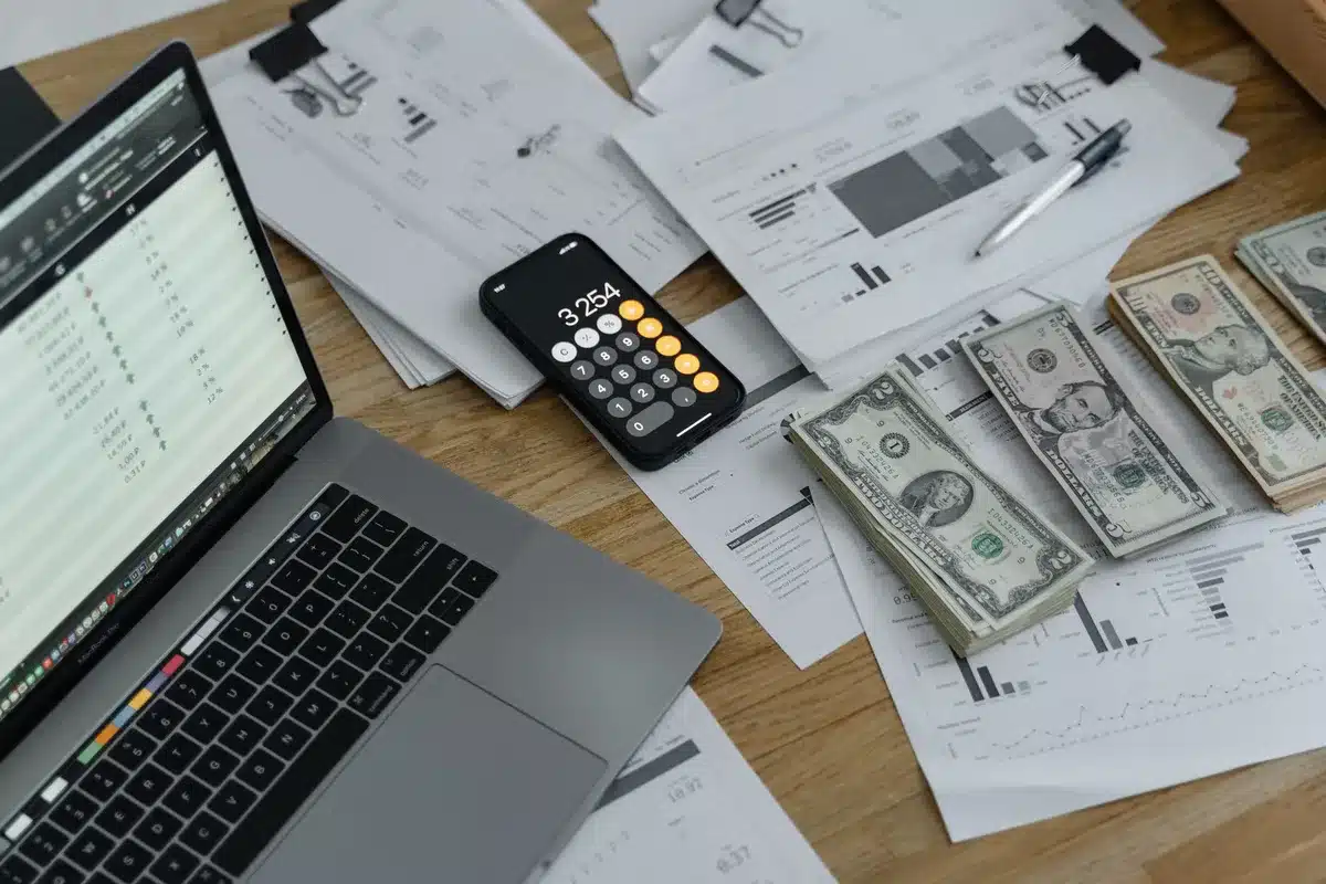 Stack of financial documents and quarterly earnings reports on a desk with a calculator