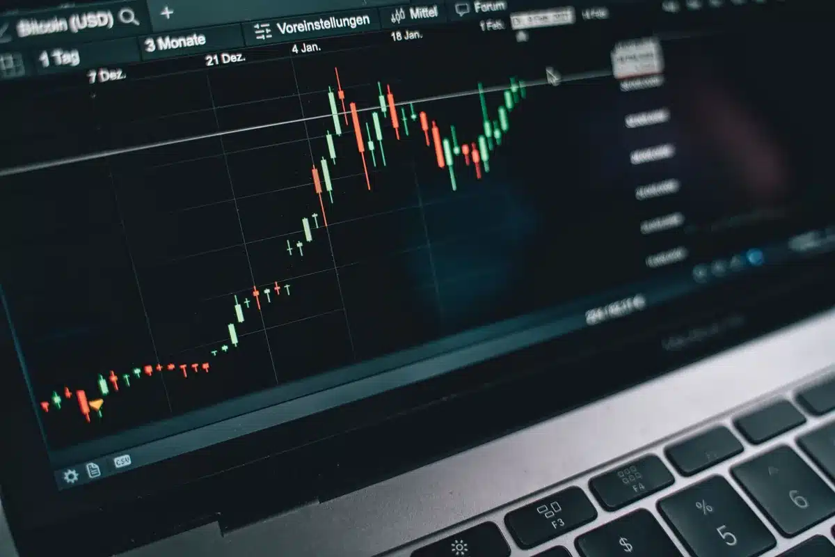 Empty cryptocurrency trading desk with monitors off, a single Bitcoin symbol on a faded screen, dim blue office lighting, abandoned trading floor atmosphere