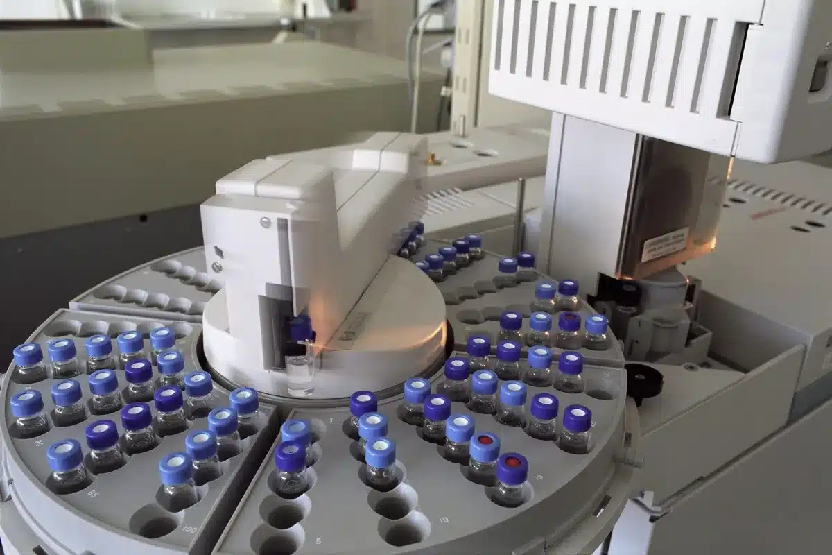 Sleek modern pharmaceutical research facility with scientists in protective gear working in a sterile laboratory, glass windows showing a cityscape beyond, cold blue-white lighting