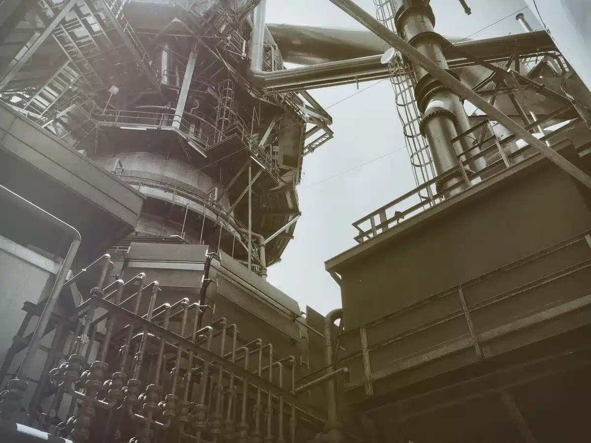 Industrial generator equipment on a manufacturing floor, metallic surfaces catching light, assembly line in soft focus, precision engineering detail