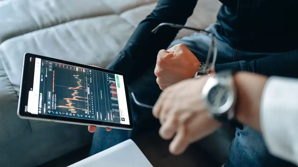 Portfolio manager analyzing stock screens and financial charts, hands on keyboard amid glowing monitors displaying market data and AI infrastructure stocks, cool blue lighting