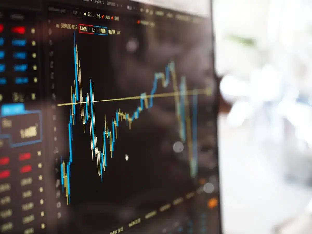 Portfolio manager reviewing stock positions on multiple screens during market downturn, data flowing across displays, focused concentration amid market volatility