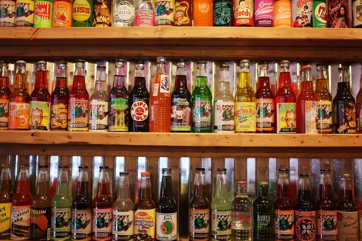 Energy drink cans on retail shelf with price tags and promotional signage