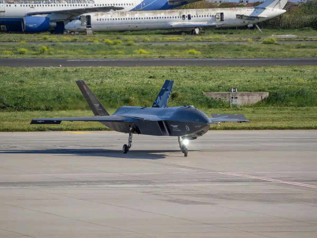 Military personnel in a command center monitoring multiple drone feeds on screens, blue-tinted tactical displays glowing in a dim room, focus on the coordination of unmanned systems across air, surface, and subsurface domains