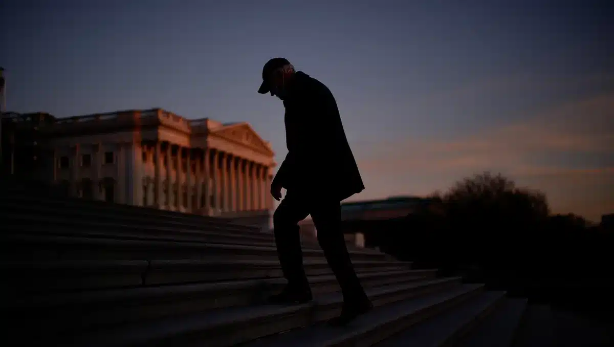 Capitol building exterior at dusk, empty steps, single figure walking away in silhouette, fading light, solitary departure suggesting withdrawal.