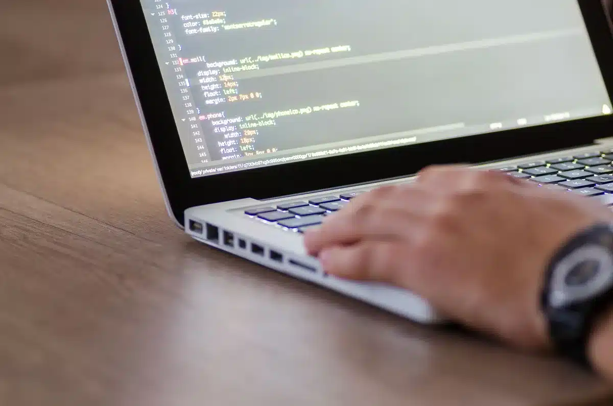 Silhouette of a developer at a workstation with glowing code on screen, representing AI-driven platform development