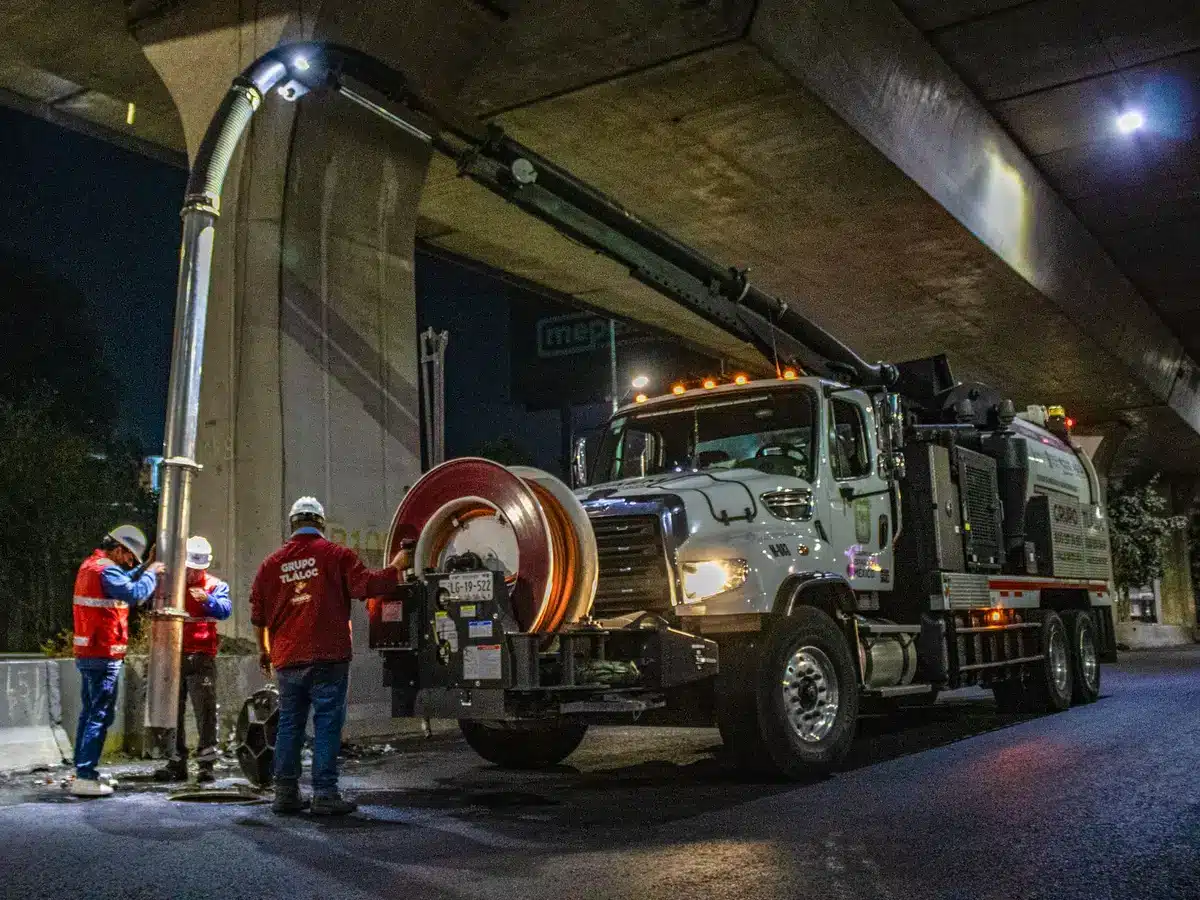ComEd utility trucks and crews working on power line restoration at dusk, with orange work lights illuminating the scene and residential homes visible in the background.