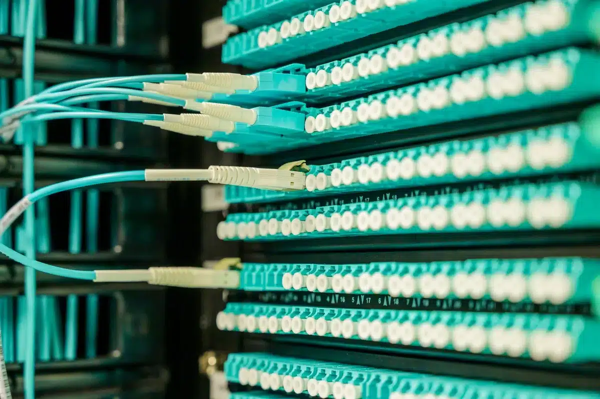A glowing server rack in a secure facility, blue and white light reflecting off metal, rows of computing equipment stretching into focused depth, a classified environment aesthetic
