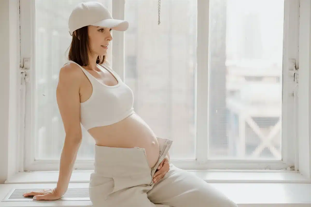 A smartphone screen displaying vital sign metrics during pregnancy monitoring, with blood pressure and heart rate readings visible on the app interface