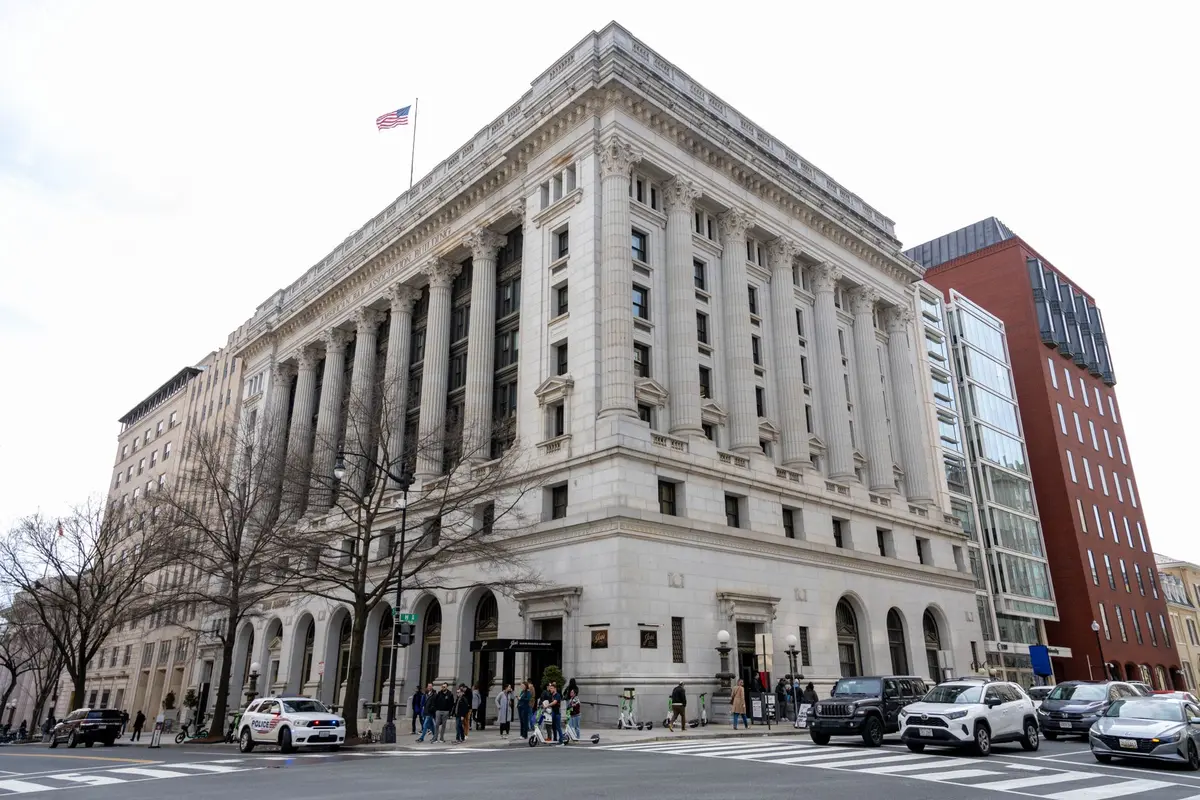 A Federal Reserve building entrance or monetary policy symbol, such as a gavel on a desk with financial documents, in neutral lighting suggesting institutional authority
