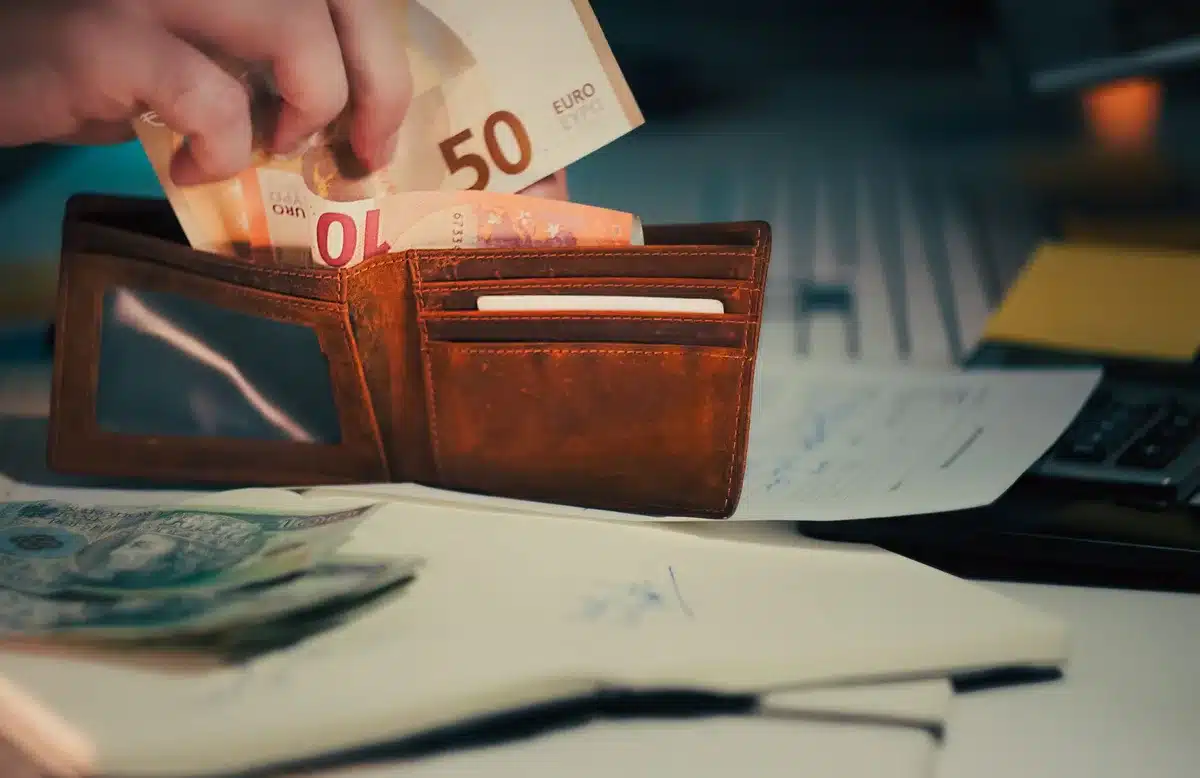 Empty wallet or financial statement showing red numbers in dim lighting, suggesting financial strain