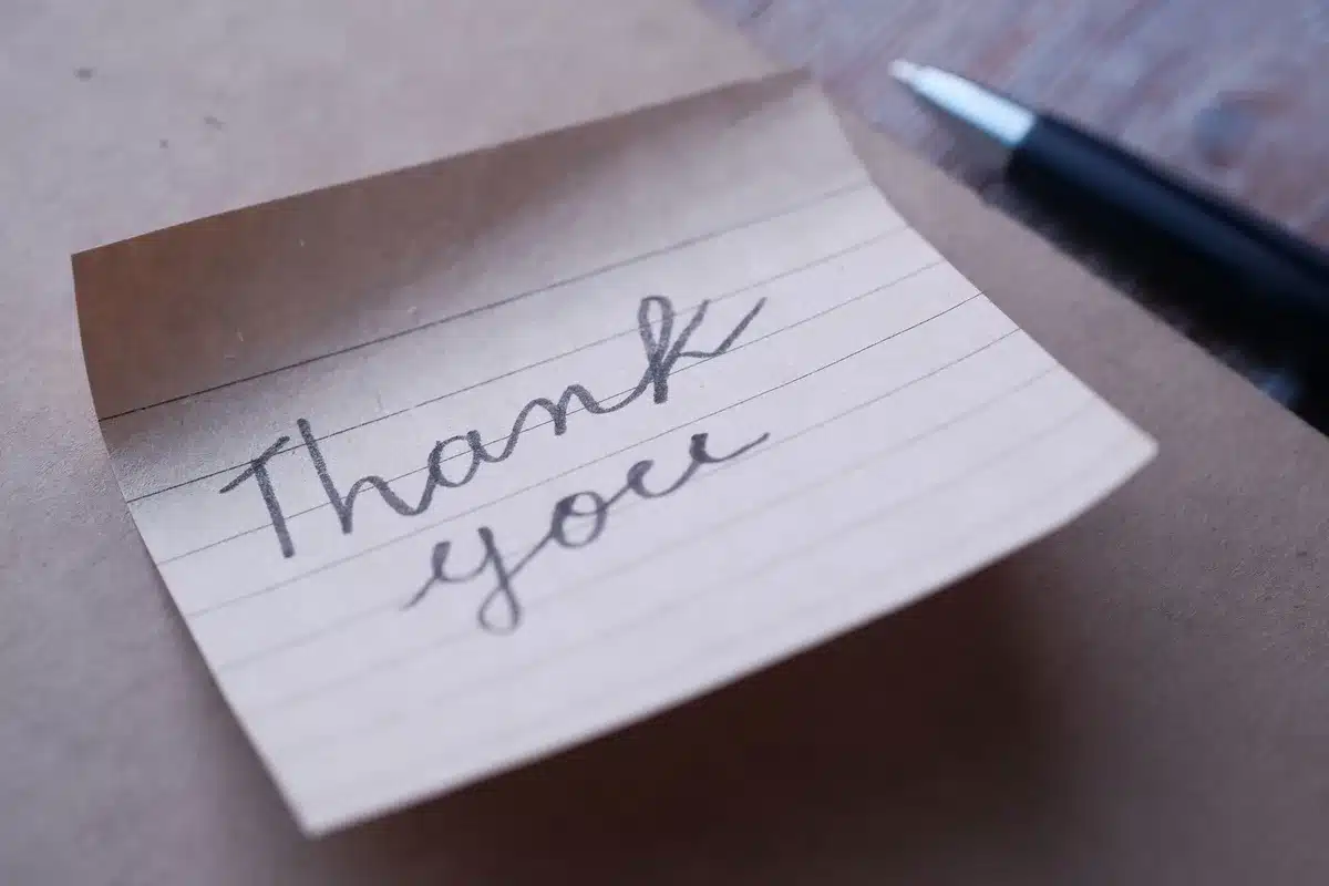 Folded handwritten letter on a desk with formal stationery, words visible including personal phrases, candlelit desk setting