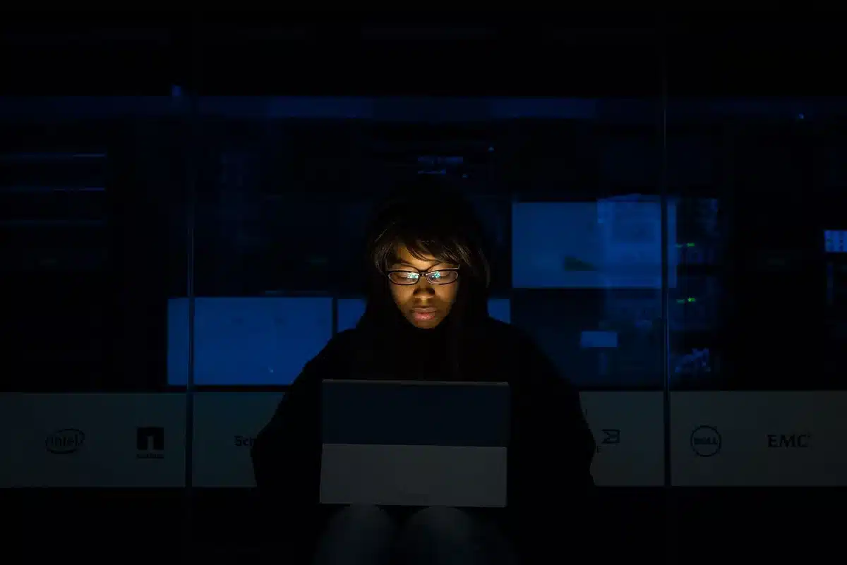 A sleek data center server rack glowing with blue and green network lights, monitoring dashboards reflected on glass surfaces, abstract streams of data flowing across screens, capturing the essence of cloud infrastructure and observability.