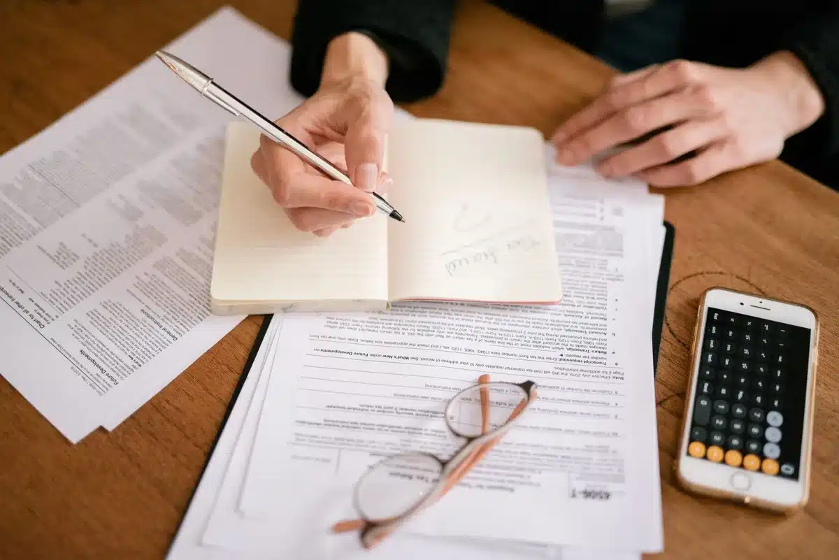 Retirement planning documents spread on desk with calculator and pension statements