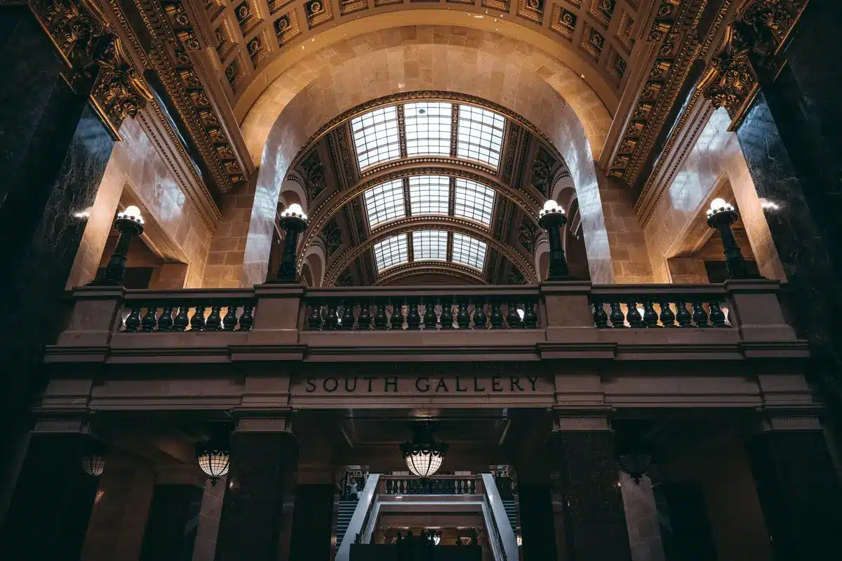 An empty gubernatorial office or capitol building corridor, austere and formal, with a single vacant chair or podium catching institutional light, suggesting power and the weight of office