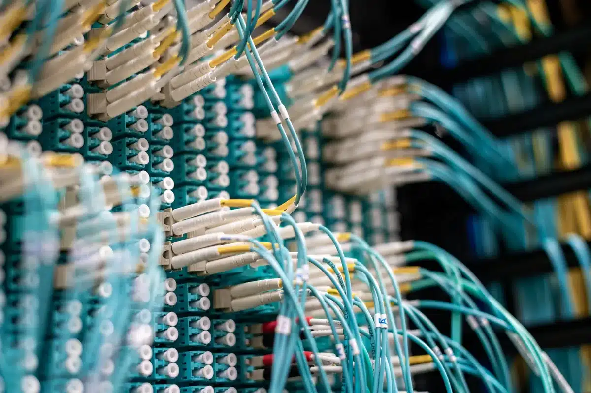 Glowing server racks with blue LED lights stacked in a data center, cables organized vertically, cool blue ambient lighting