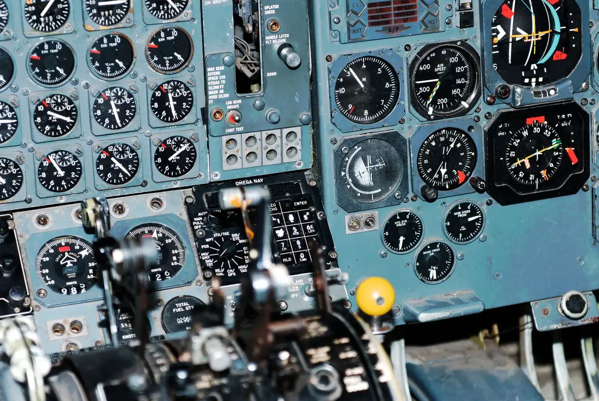 Airbus A321 cockpit interior, instrument panel illuminated, oxygen masks hanging from ceiling compartment, seats empty