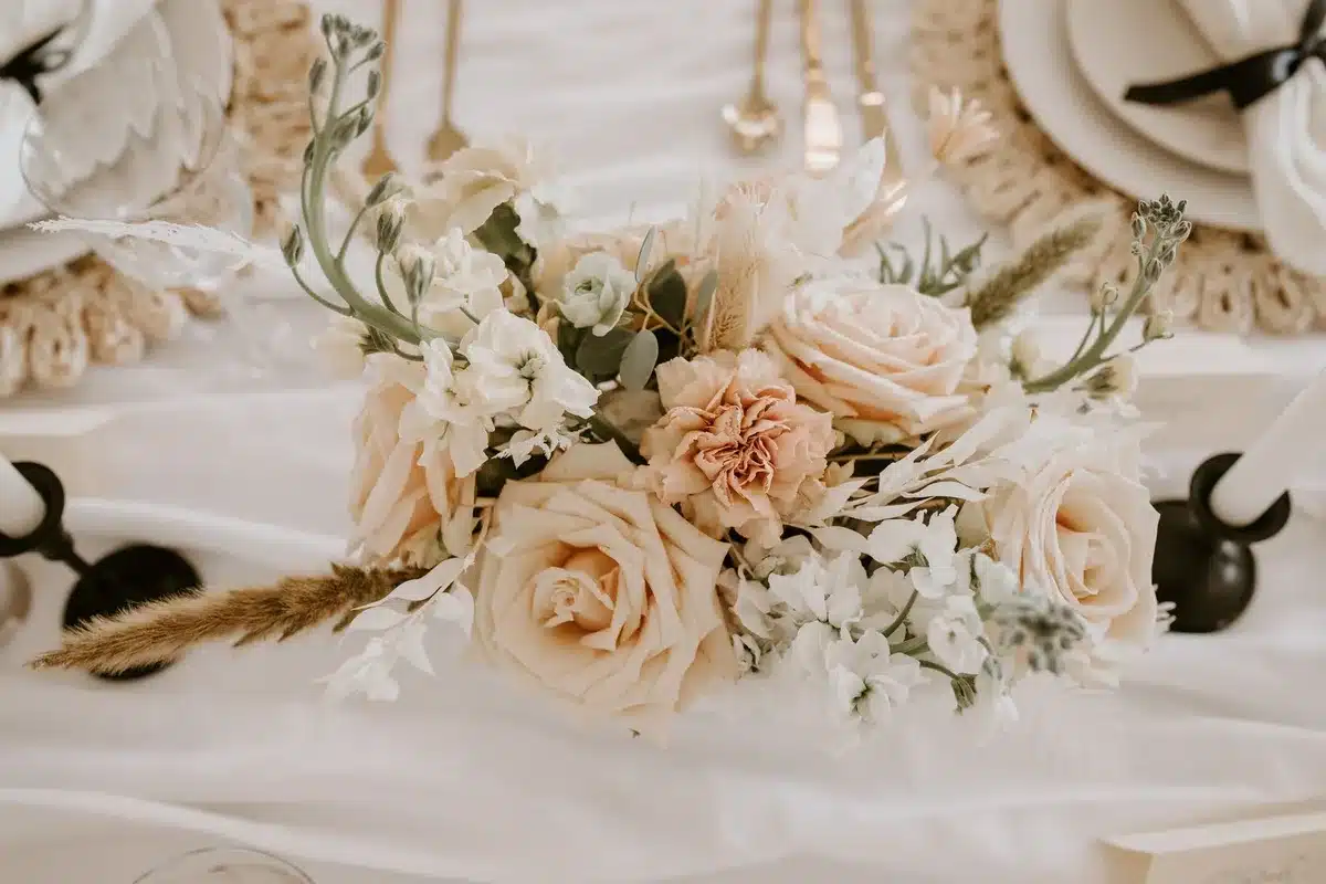 A wedding celebration scene with champagne glasses and flowers on a table, captured in warm candlelight, evoking the intimate family moment of a meaningful gift exchange.