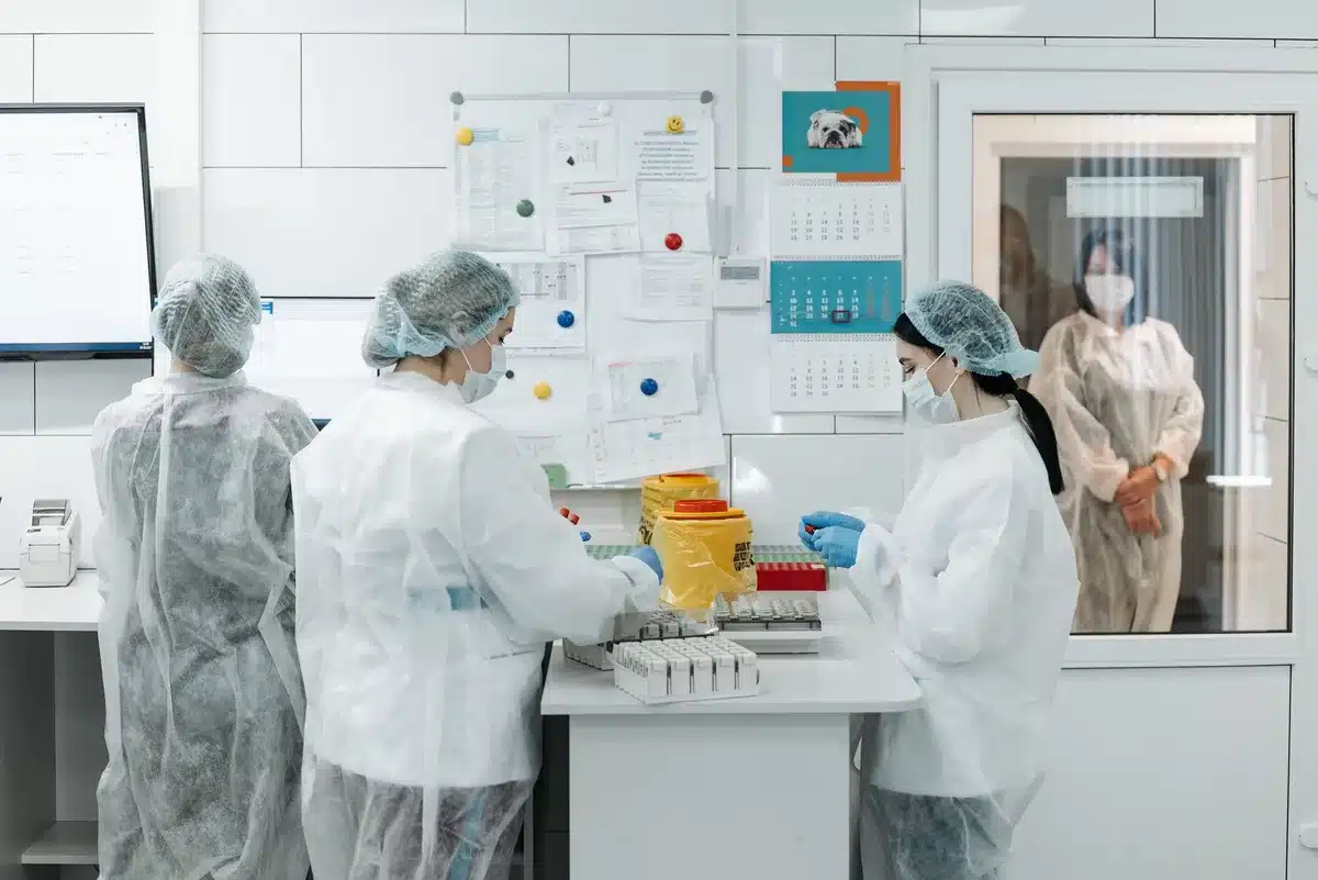 A darkened AI research lab with rows of humming server racks, blue LED lights reflecting off metal surfaces, a few empty workstations in the foreground, conveying organizational strain and talent exodus