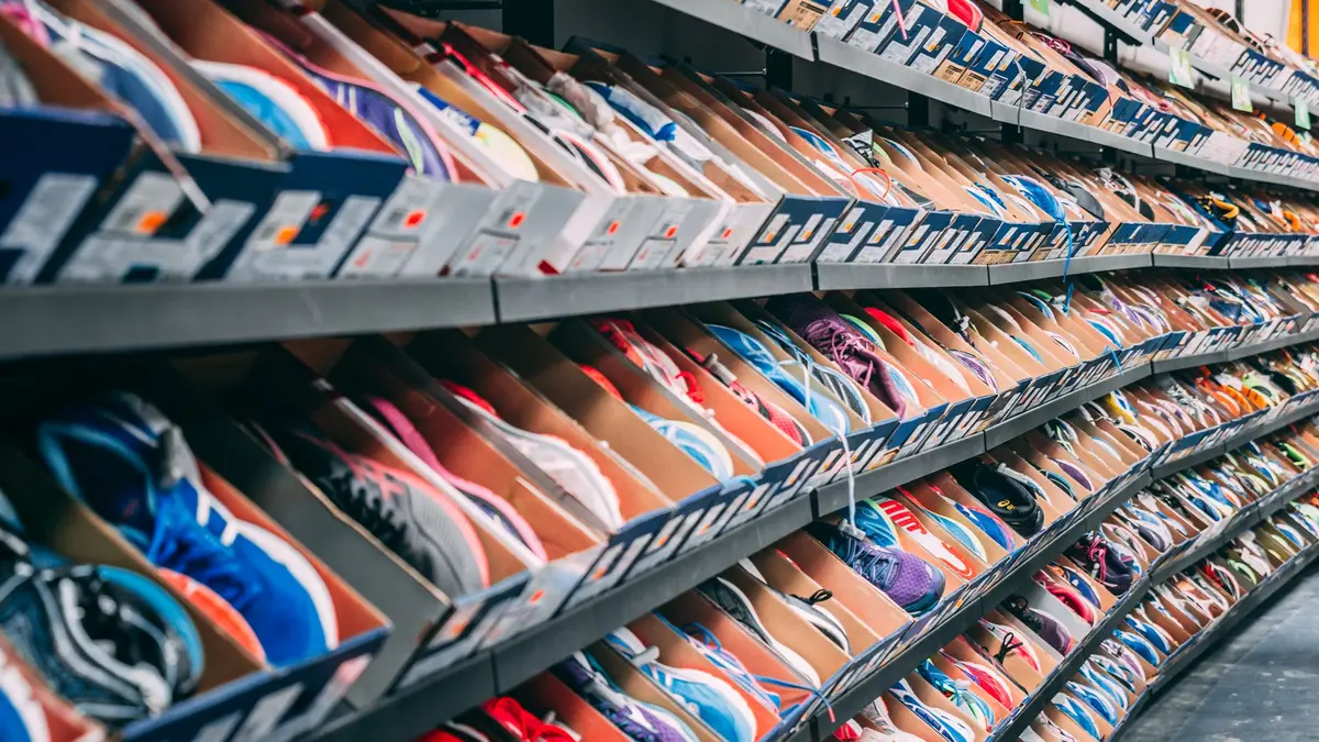 Retail store shelves with athletic apparel and footwear displays, showing product inventory and promotional signage