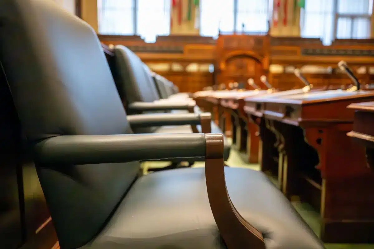 A courthouse hallway with empty benches and soft institutional lighting, symbolizing the formal legal spaces where protective orders and custody cases are decided