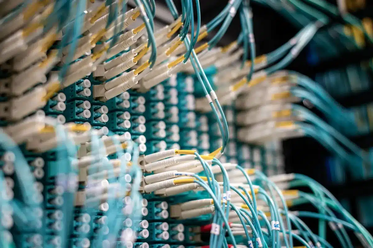 A modern data center facility with rows of server equipment and cooling systems, neon-lit server racks glowing in a climate-controlled warehouse environment, industrial efficiency and technological power