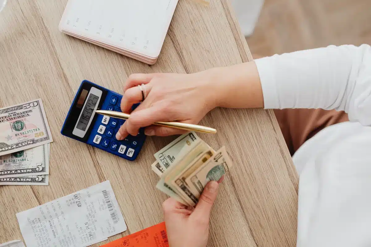 A borrower reviewing student loan account statements showing reduced payment counts on a computer screen, confusion and concern visible in the scene