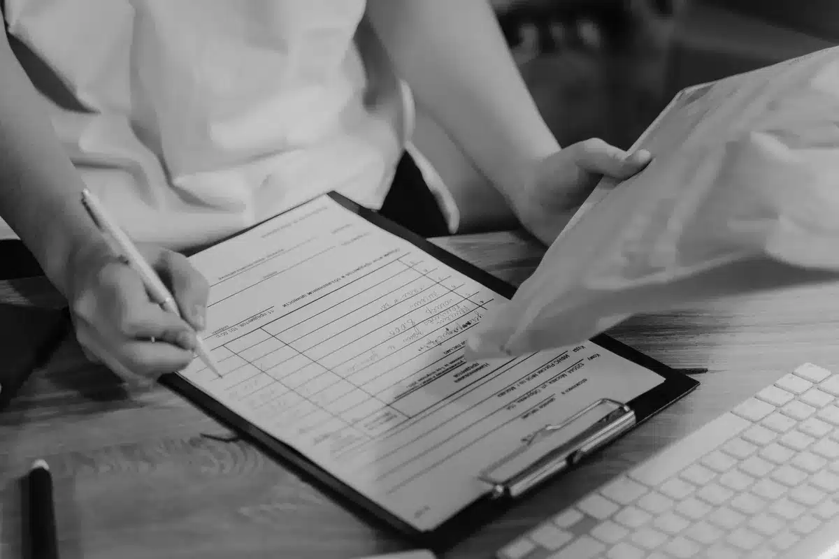 A close-up of mortgage paperwork and a calculator showing a high interest rate, with a pen resting on the documents