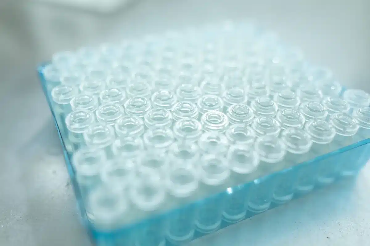 A pharmaceutical laboratory workspace with tirzepatide drug vials lined up on a shelf under laboratory lighting, sterile environment, focus on the vials