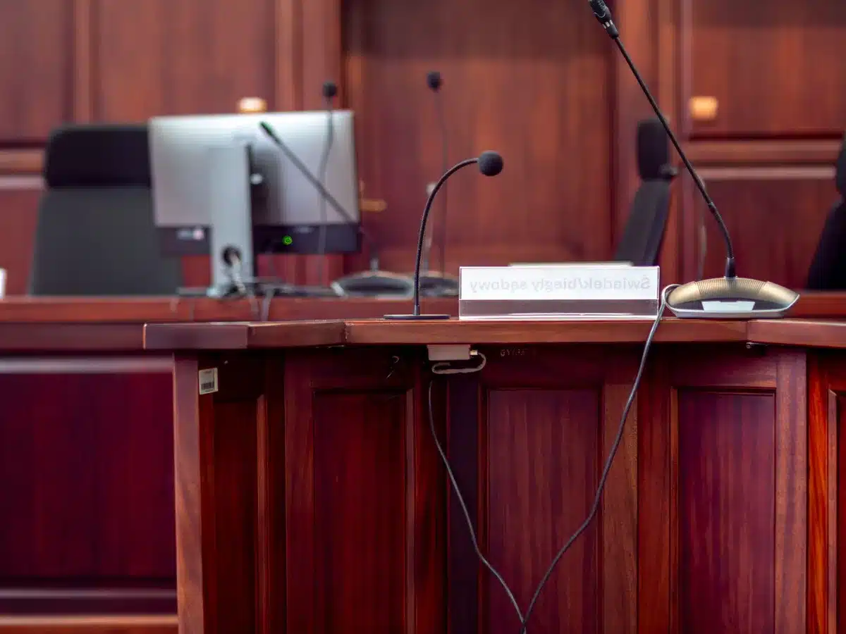 Congressional hearing room with empty witness chair, official seal on wall, muted lighting, formal wooden furniture, sense of formal accountability