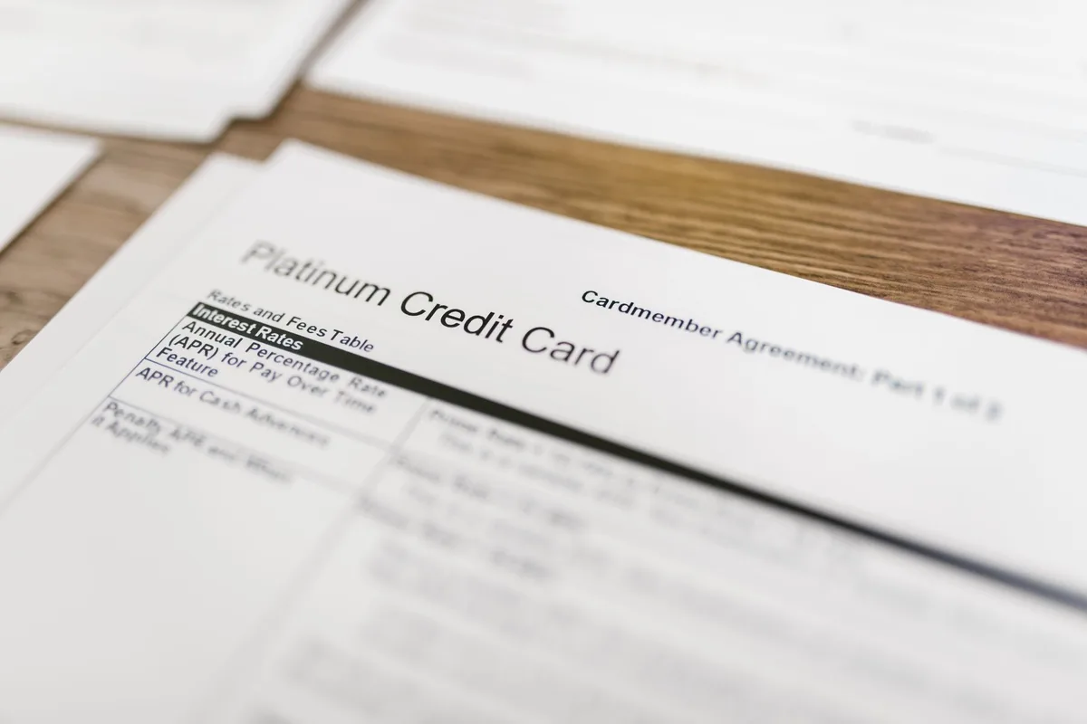 A close-up of a printed credit report document with highlighted collection account entries, showing duplicate line items side by side on white paper, emphasizing the reporting error at the center of the lawsuit.