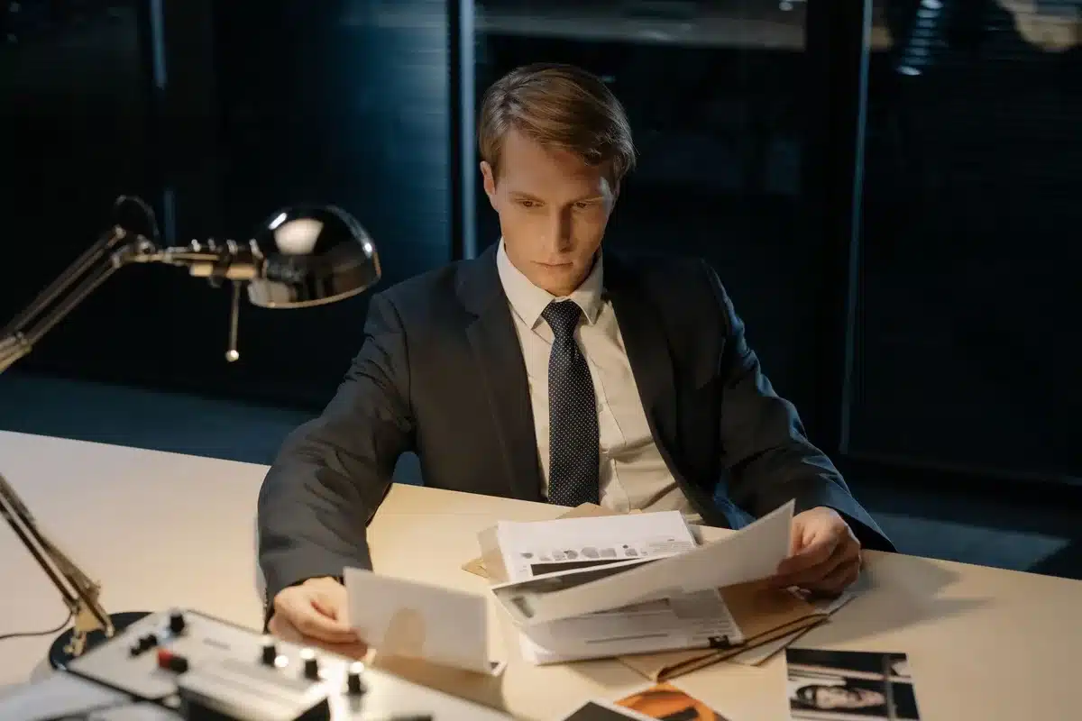 A formal government office setting with empty desk, stacked legal documents, and a gavel under office lighting