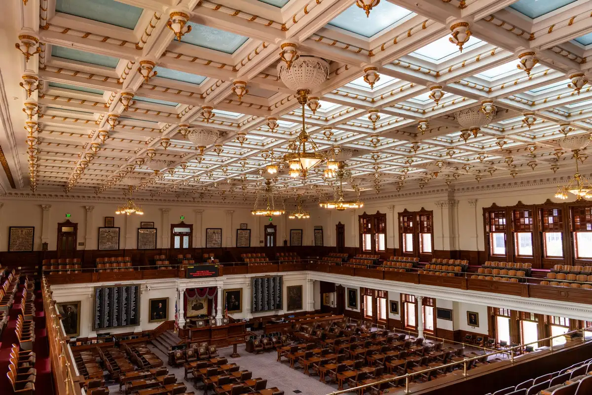 Courthouse interior with empty judge's bench and witness stand, soft morning light through tall windows, a single gavel resting on the bench, austere and solemn atmosphere, anticipation