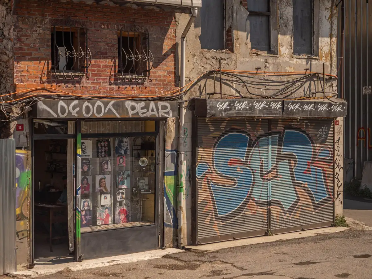 A small business storefront with a "Closed" sign in the window, dark interior, empty street, morning light