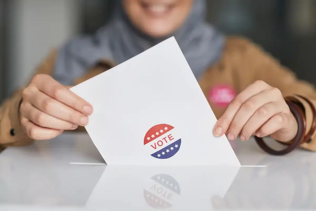 Diverse poll workers at a voting station checking in voters with clipboards and registration materials