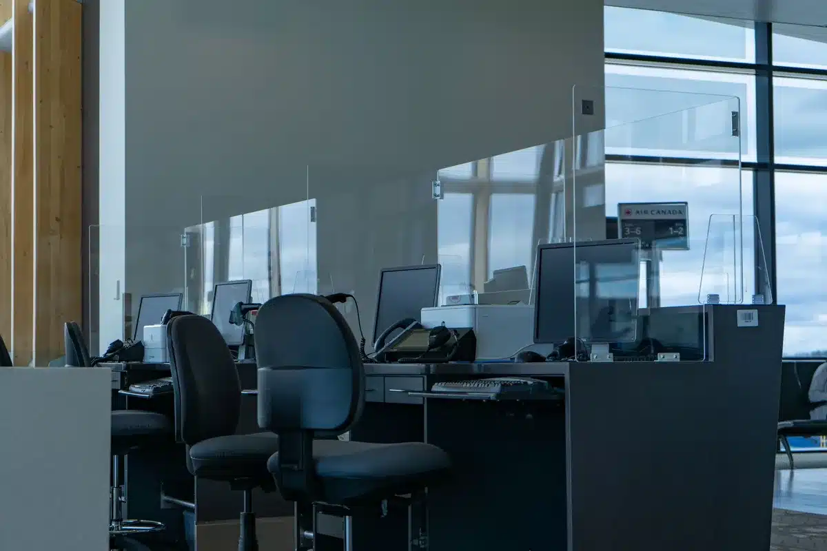 An empty bank branch interior with rows of teller windows and a quiet floor, bathed in cool fluorescent light, symbolizing traditional banking and the stagnation of savings accounts in a changing financial landscape.