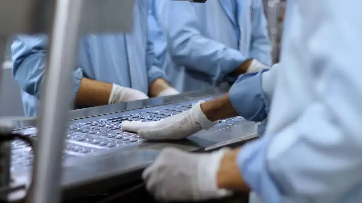 Manufacturing plant interior with workers inspecting pickup truck assembly line, quality control focus