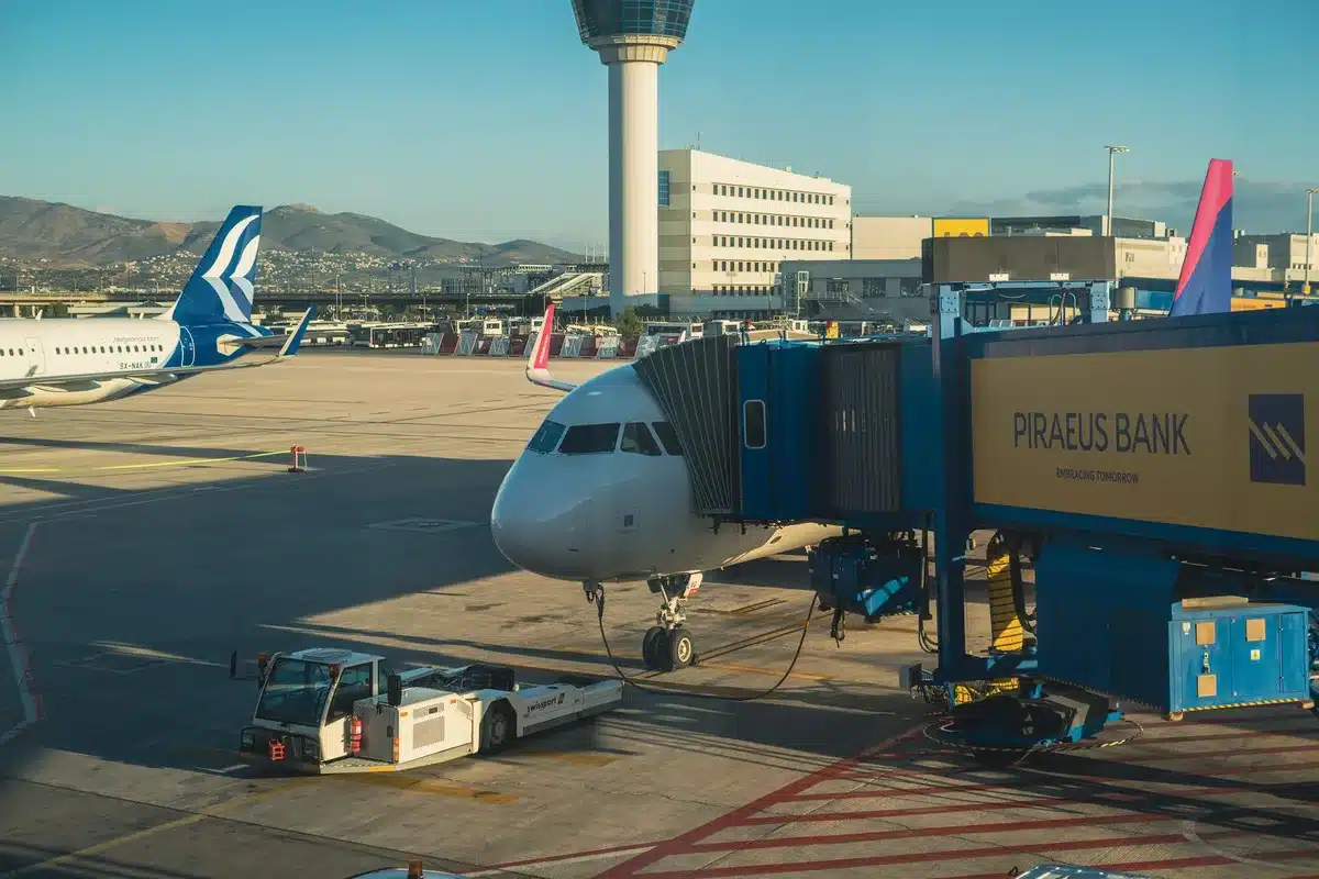A modern aircraft fuselage with Frontier branding visible on the tail, parked at a gate with ground equipment and airport infrastructure in the background, representing fleet expansion and operational growth.