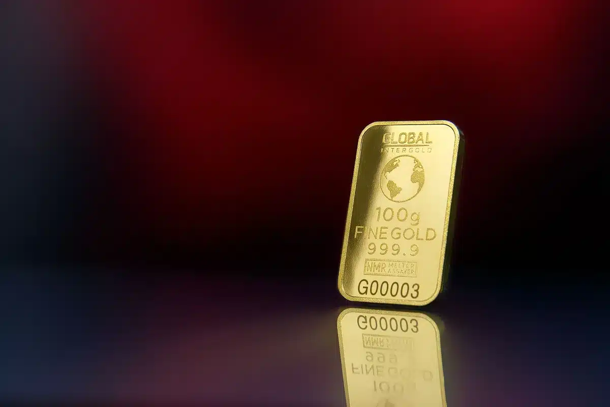 Gold bars stacked in vault, warm light reflecting off bullion, financial security symbol