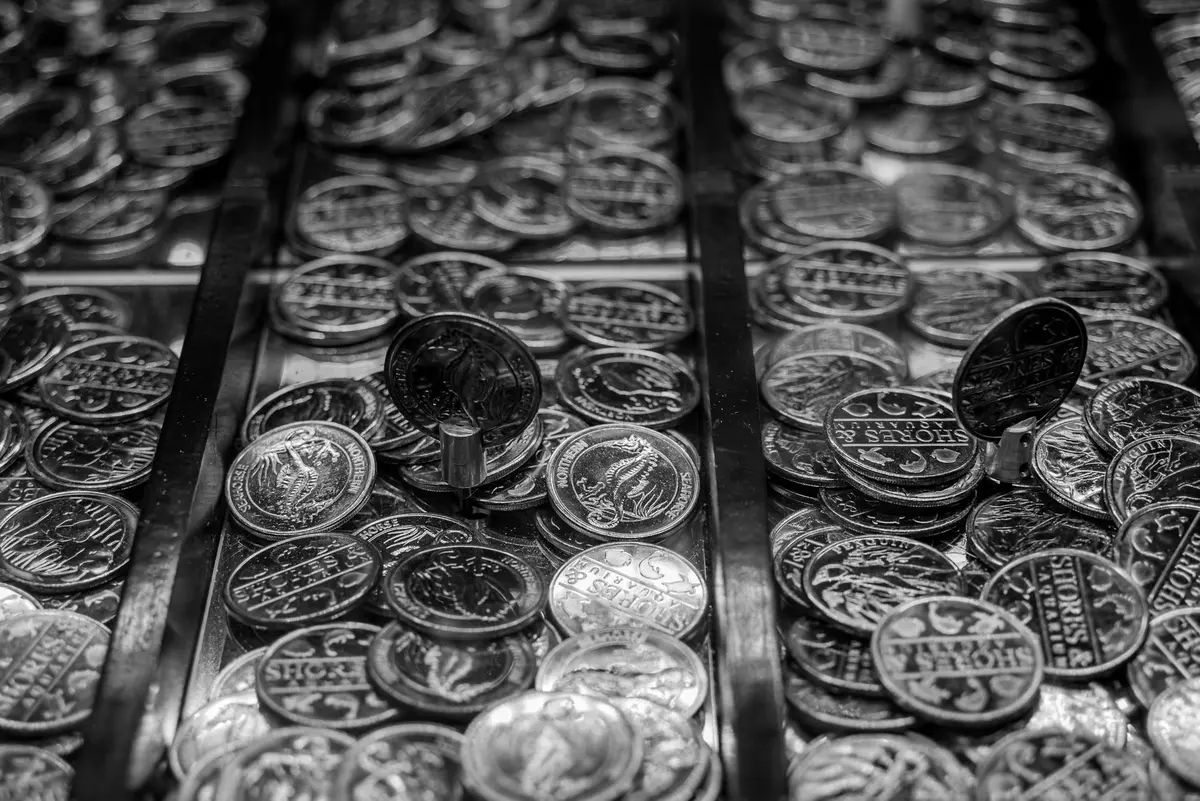 A single Treasury bond certificate and a gold coin side by side on a dark surface, symbolizing the inverse relationship between yields and precious metals