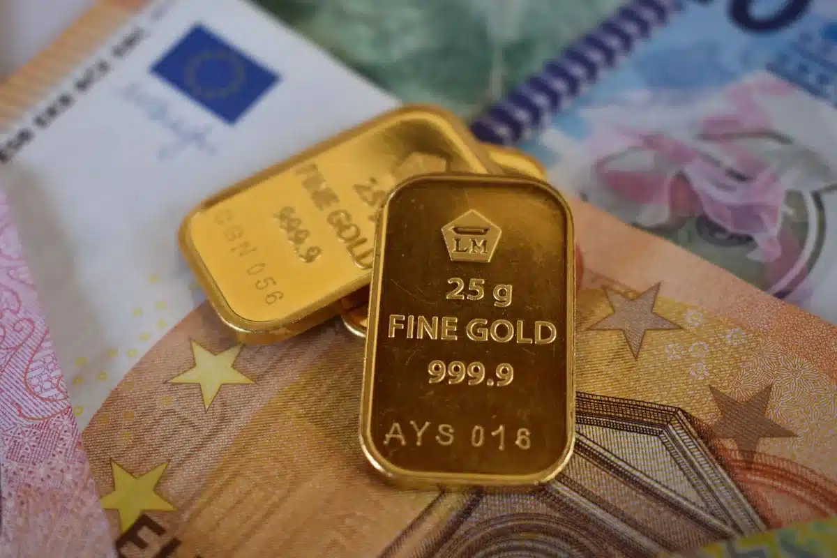Gold bars stacked in a secure vault, catching warm light from above, representing financial security and value storage amid market shifts.