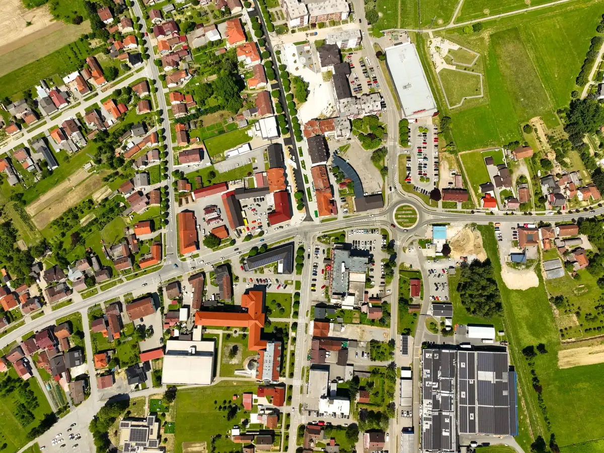 A computer screen displaying a satellite map interface with AI-generated overlay controls, showing a real landmark location with digital editing tools visible, representing geospatial manipulation