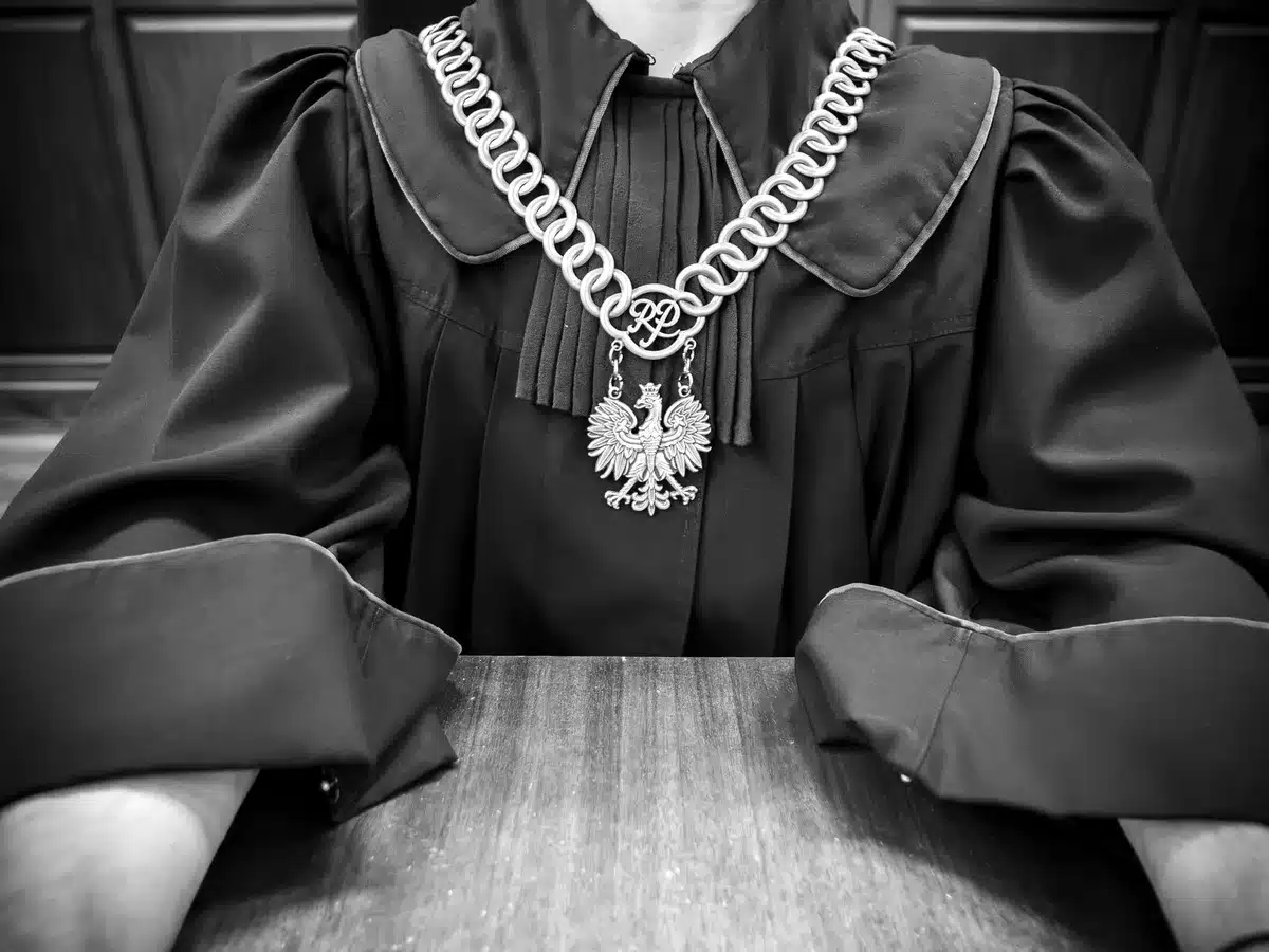 Empty Supreme Court chamber with nine ornate justice seats facing away from camera, judicial bench under soft spotlight, law books lining mahogany shelves, solemn institutional atmosphere
