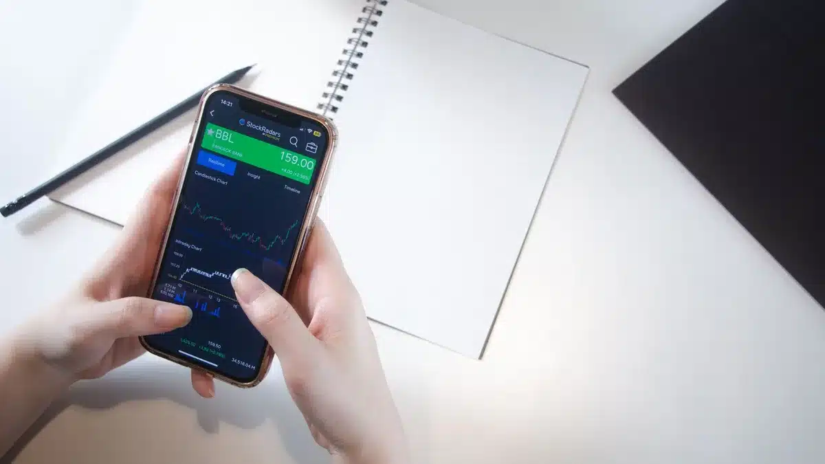 Anonymous investor reviewing portfolio statements on a screen, dividend yield percentages glowing softly in the background, papers with financial data spread across desk
