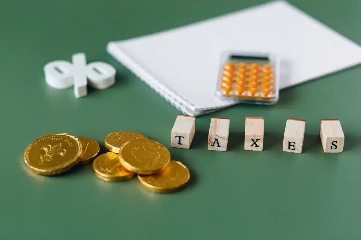 Spreadsheet showing tax bracket comparison table with annual savings calculations, numbers highlighted in contrasting colors, calculator visible in corner
