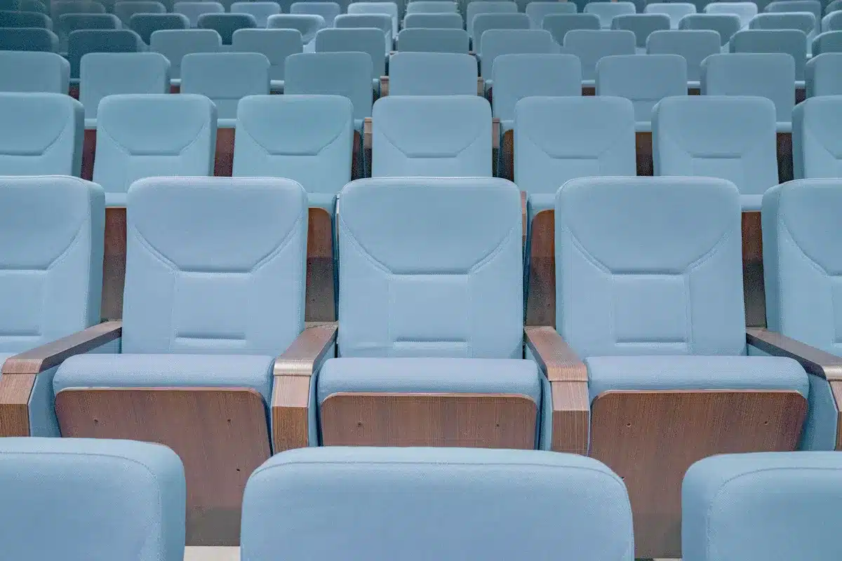 A state capitol building or legislative chamber interior with empty seats, institutional setting, quiet and formal