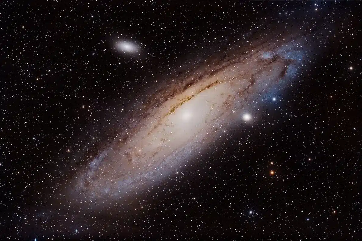 Hubble mosaic of Andromeda galaxy showing blue star-forming regions contrasting with red older stellar populations across the galactic disk